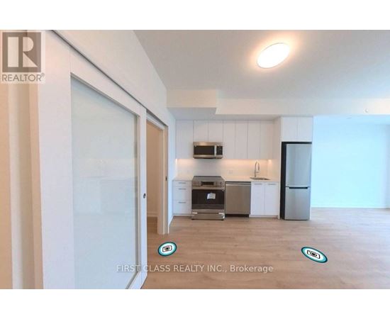 A kitchen area with a refrigerator, oven, and sink.