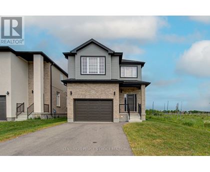 A house with a grey roof and a garage door is for sale.