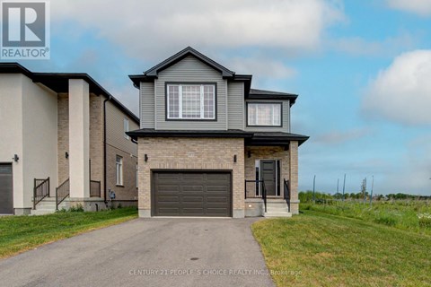 A house with a grey roof and a garage door is for sale.
