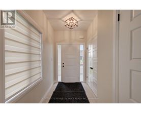 A hallway with white walls and a black doormat.