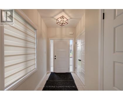 A hallway with white walls and a black doormat.