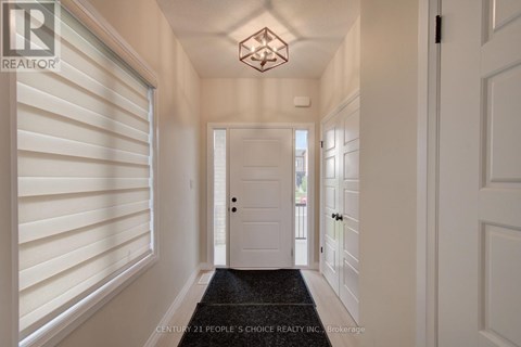 A hallway with white walls and a black doormat.