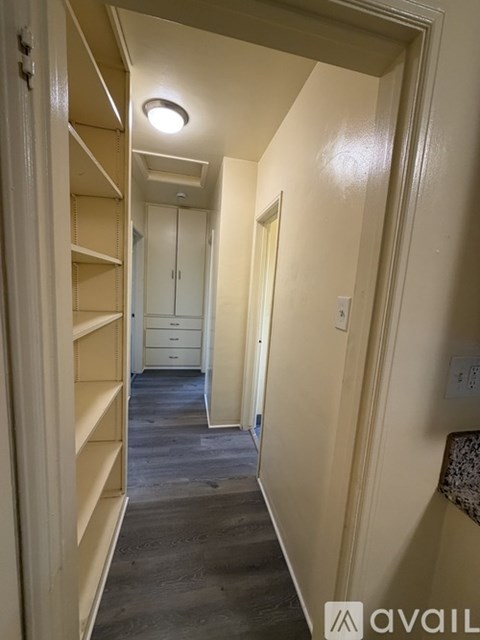 A hallway with a light on the ceiling and a door at the end.