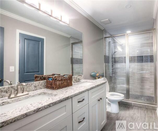 A bathroom with a sink, toilet, and shower.