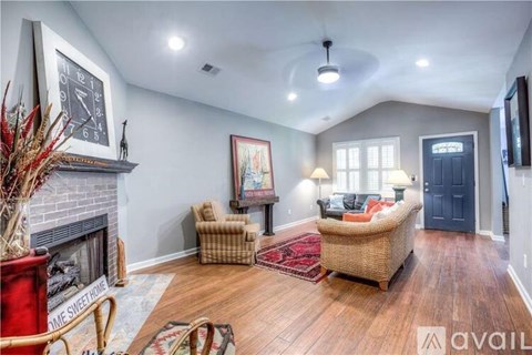 A living room with a fireplace and a painting on the wall.