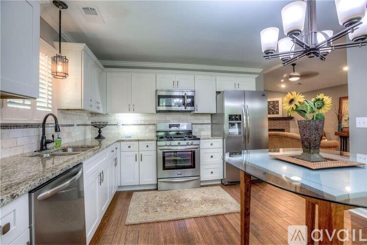 A modern kitchen with white cabinets and stainless steel appliances.