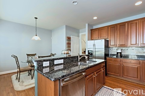 A kitchen with brown cabinets and a black granite countertop.