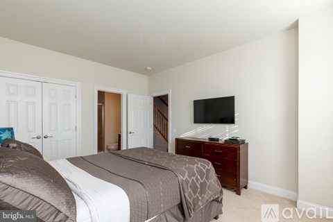 A bedroom with two beds and a television.