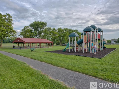 A playground with a red roof and a green slide.