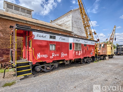 A red train car with the words "Nickel Plate Road" on it is parked in front of a building.
