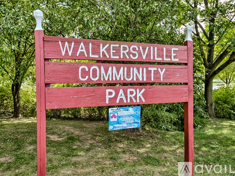 A red sign that says "Walkersville Community Park" in front of trees.