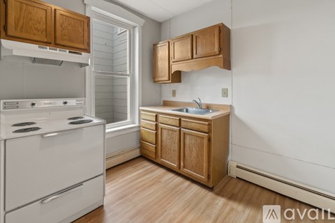 A kitchen with wooden cabinets and a white oven.