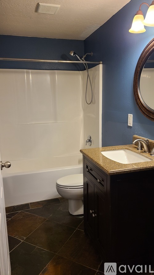 A bathroom with a white toilet and a white bathtub.