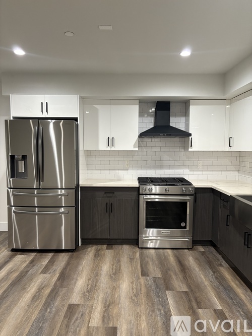 A modern kitchen with a stainless steel refrigerator and oven.