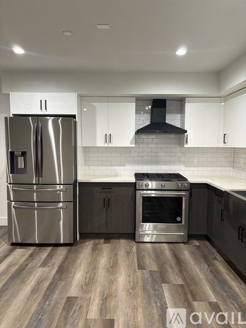 A modern kitchen with a stainless steel refrigerator and oven.