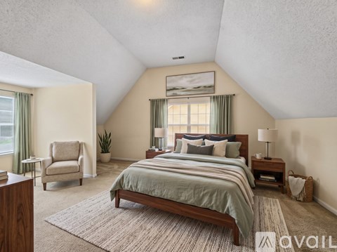A bedroom with a large bed and a chair.