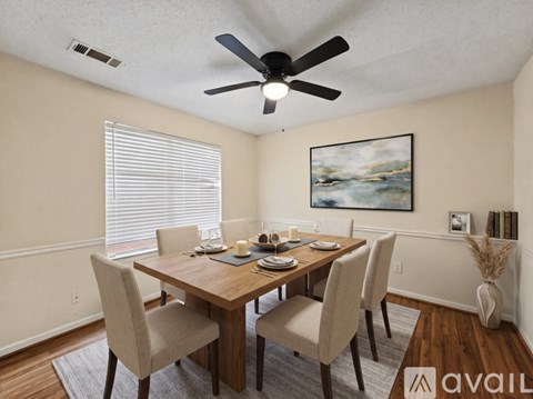 A dining room with a wooden table and chairs.