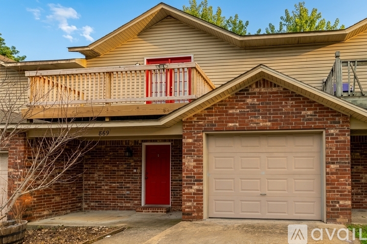 A house with a red door and a garage door is for sale.