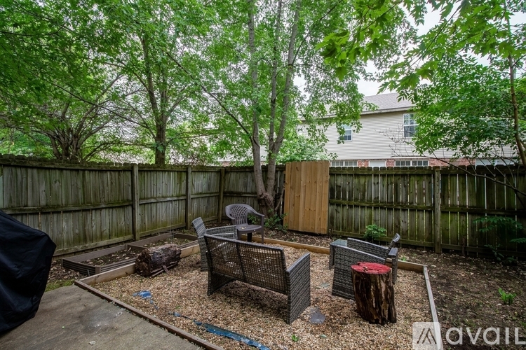 A backyard with a wooden fence and a tree.