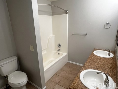A white toilet is next to a bathtub in a bathroom.