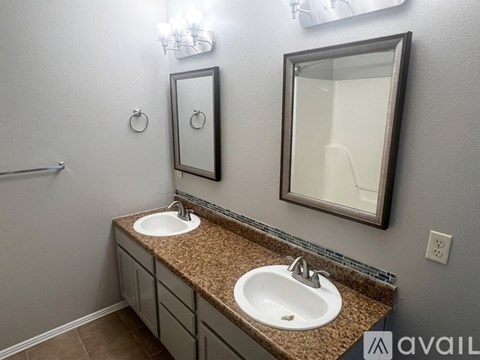 A bathroom with two sinks and a mirror.