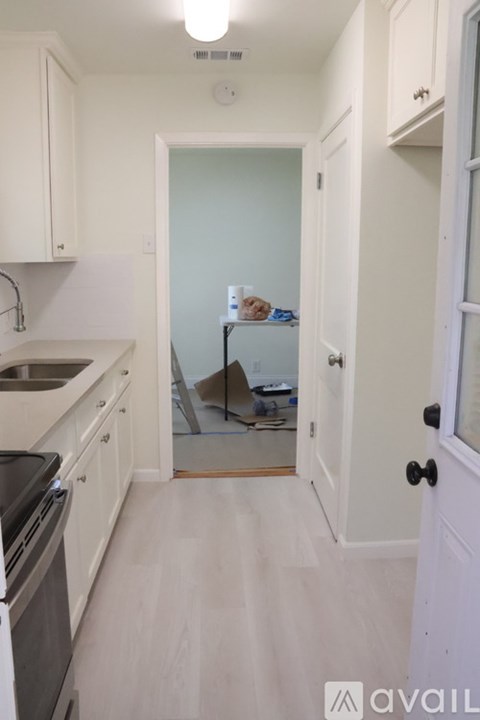 A kitchen with white cabinets and a black stove top oven.