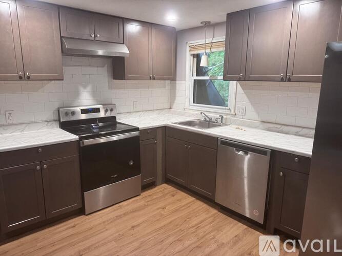 A kitchen with dark wood cabinets and stainless steel appliances.