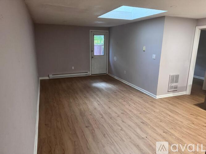 A room with wooden flooring and a skylight.