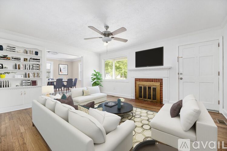 A living room with a white couch and a fireplace.