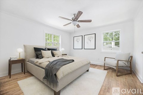 A bedroom with a bed, chair, and pictures on the wall.