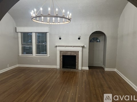 A living room with a fireplace and a chandelier.