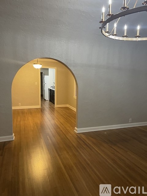 A room with wooden floors and a chandelier.