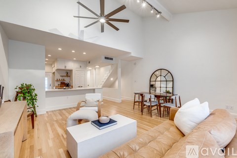 A living room with a white couch and a wooden floor.