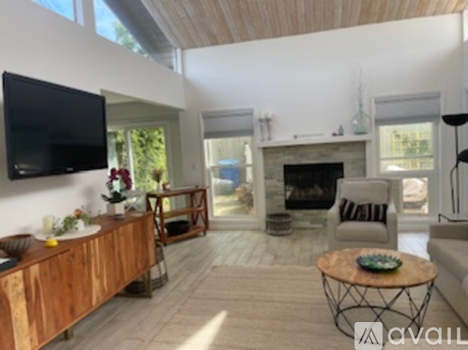 A living room with a fireplace and a television mounted on the wall.
