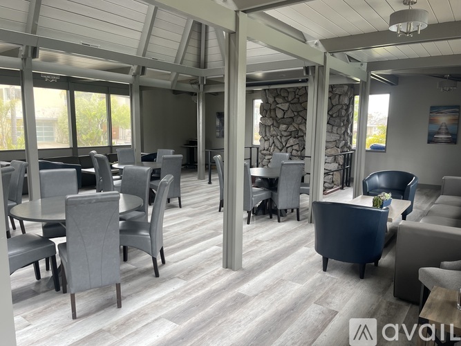 A modern dining room with grey chairs and a wooden floor.