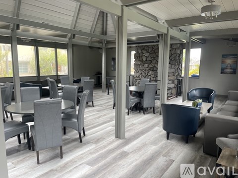 A modern dining room with grey chairs and a wooden floor.