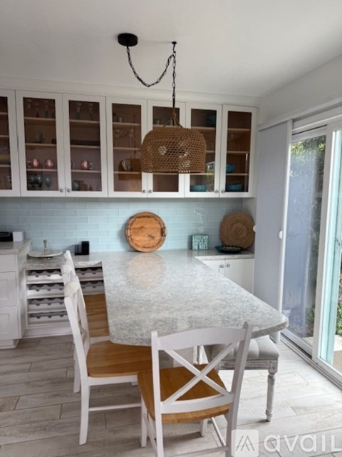 A kitchen with a table and chairs.