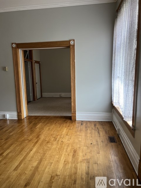 A room with wooden floors and a large open doorway.