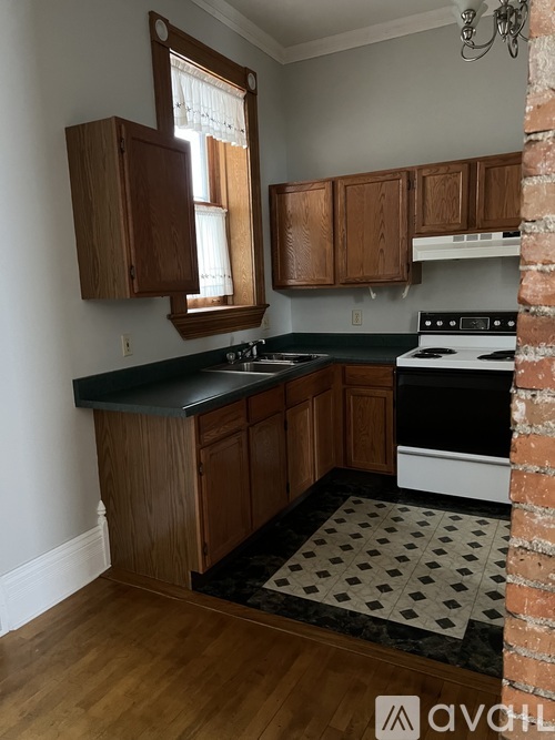 A kitchen with wooden cabinets and a white stove.