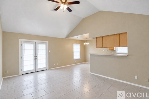 A spacious room with a ceiling fan and tiled flooring.