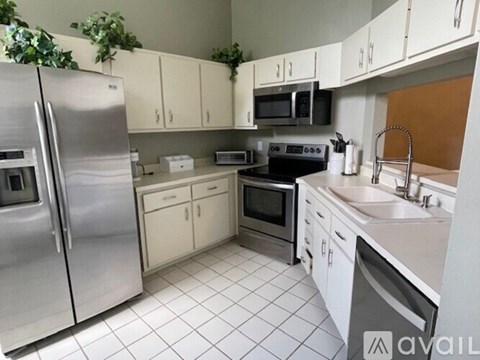A kitchen with white cabinets and appliances.