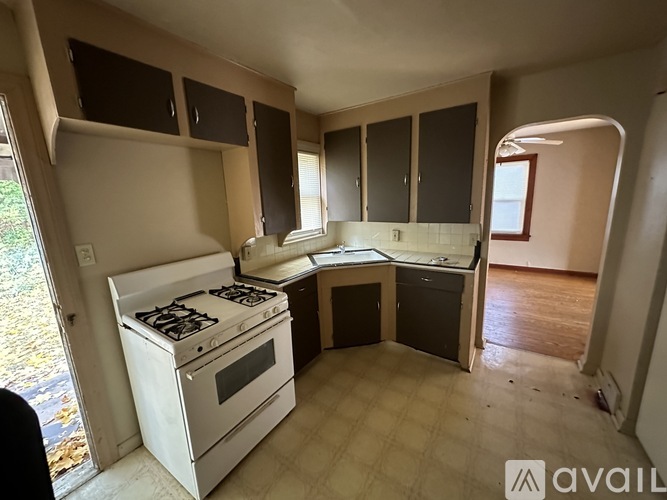 A kitchen with a white stove and cabinets.