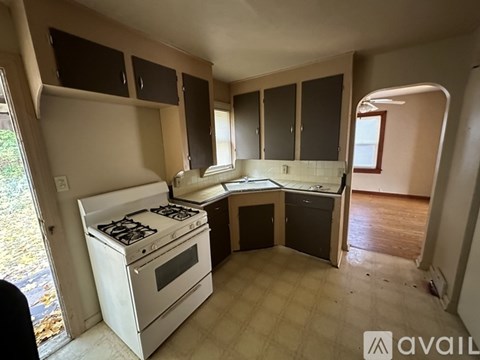 A kitchen with a white stove and cabinets.