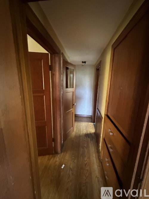 A long hallway with wooden doors on both sides.