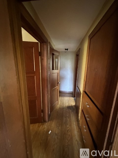 A long hallway with wooden doors on both sides.