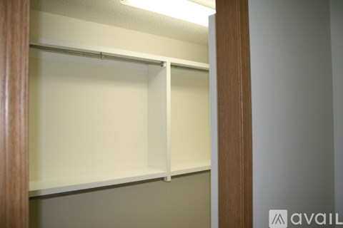 A white shelf in a room with a wooden door.