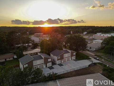 A sunset view of a neighborhood with houses and a parking lot.