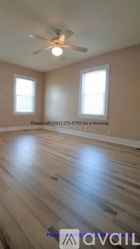 A room with a window and a phone number on the wall.