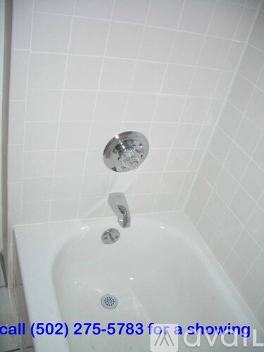 A white bathtub with a shower head and faucet.