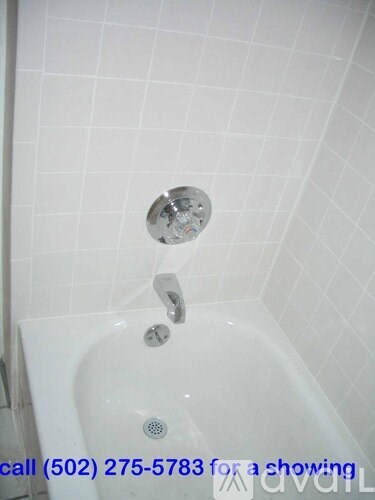 A white bathtub with a shower head and faucet.